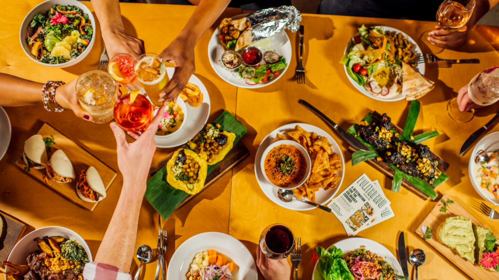 A table with hands reaching out for a variety of dishes