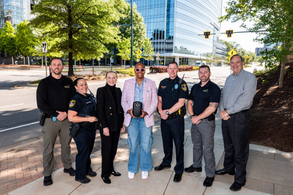 Key figures from the Dunwoody Police Department, Perimeter Community Improvement Districts, and the City of Dunwoody pose with the new Flock Safety Falcon license plate reader as part of their public safety technology initiative.